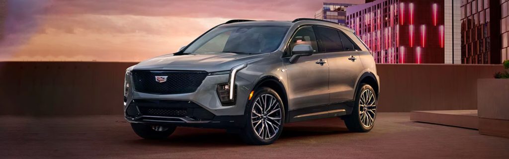 A silver 2025 Cadillac XT4 parked in an urban setting during sunset.