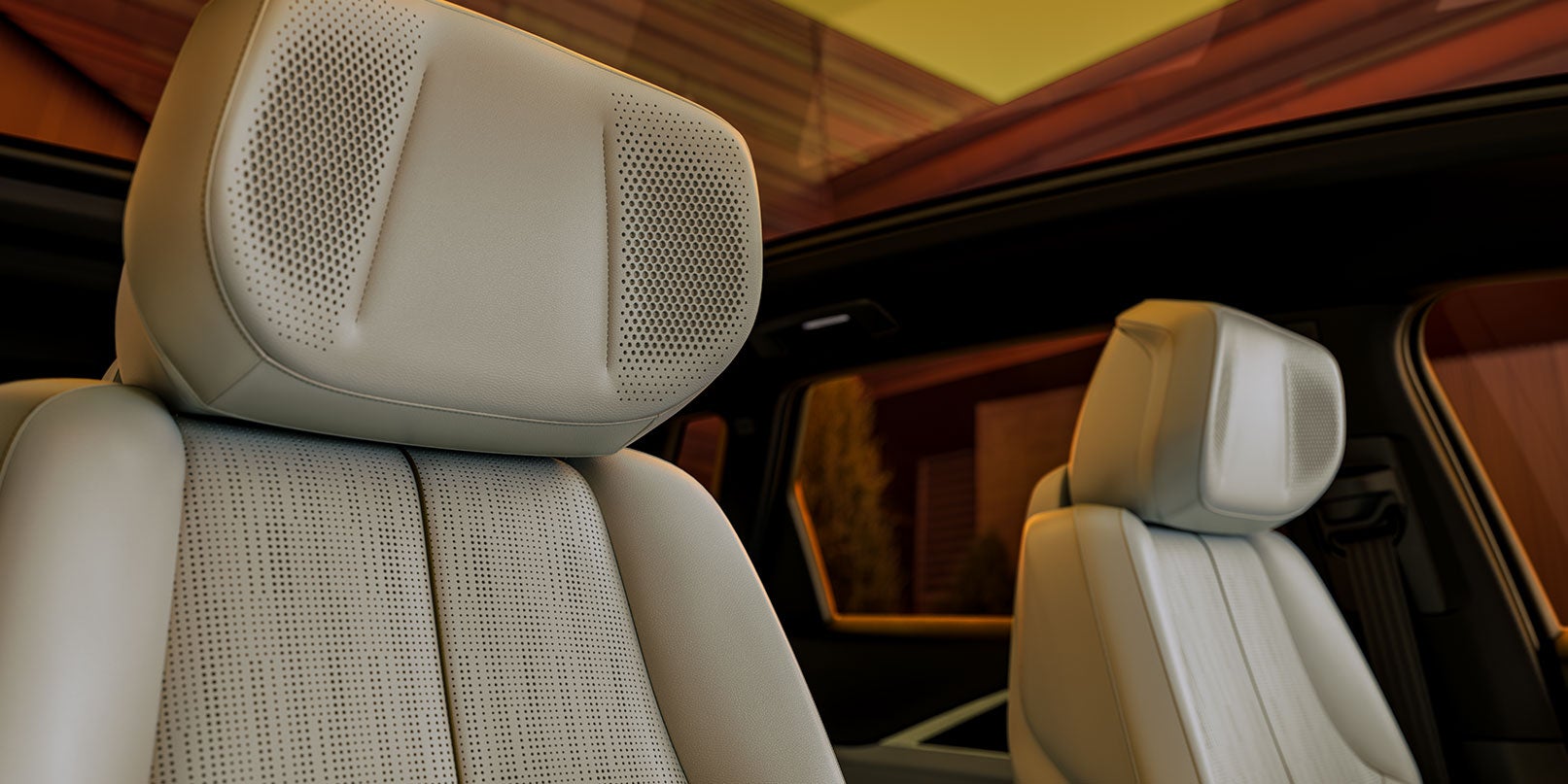 Close-up of a perforated leather car seat and headrest under a sunroof
