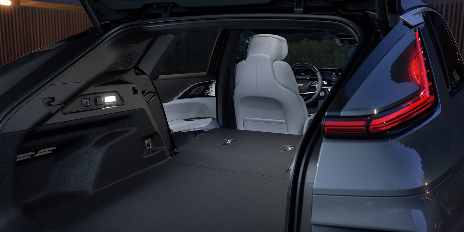 View of the SUV cargo area with folded rear seats and illuminated taillight.